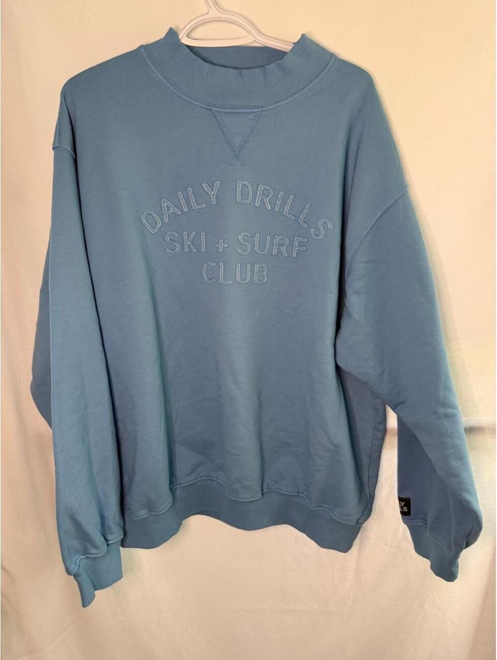 Daily Drills blue crewneck sweatshirt with 'DAILY DRILLS SKI + SURF CLUB'